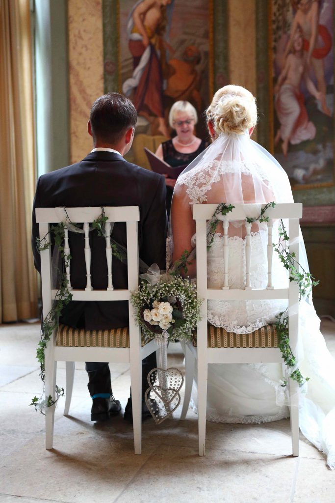 Brautpaar sitzend auf Stühlen - Foto von hinten