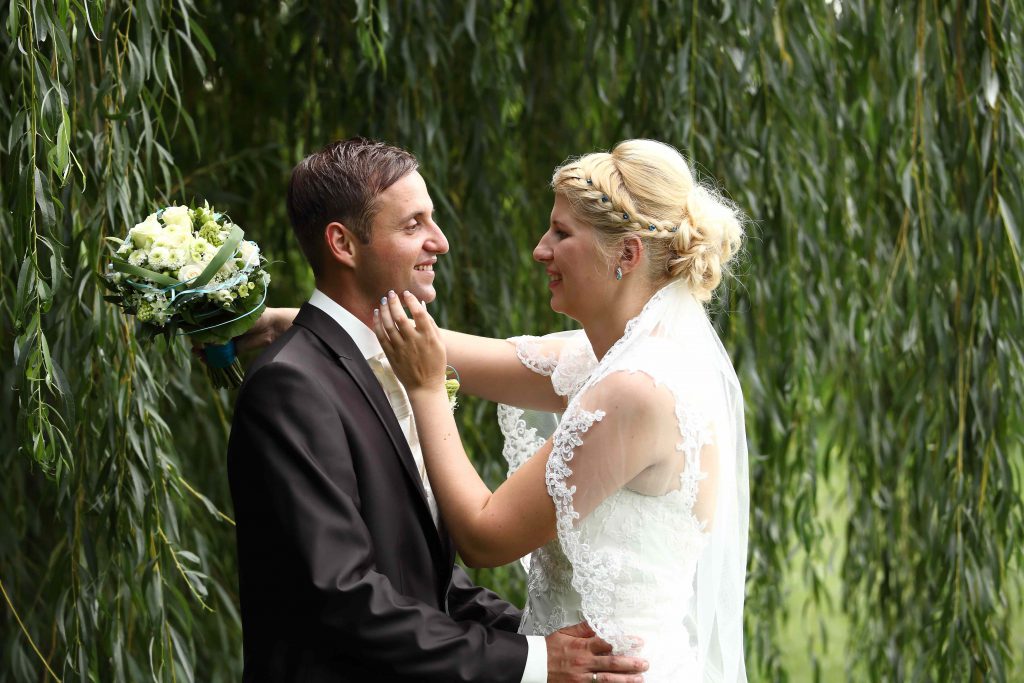 Brautpaarfoto - zärtlich unter einer Weide